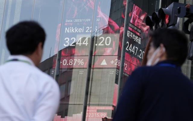 A stock market board featuring Japan's Nikkei 225 index outside a securities firm in Tokyo. 

Image Source: The Associated Press 